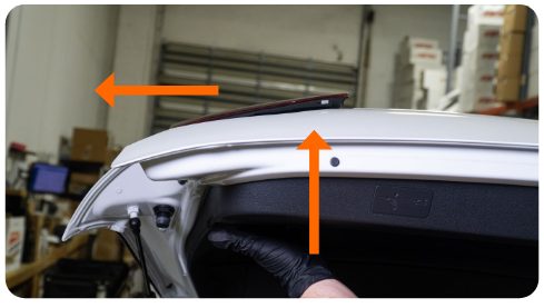 Arrows showing the inner tail light being pushed up and then outward off the hatch of a MK8 Golf