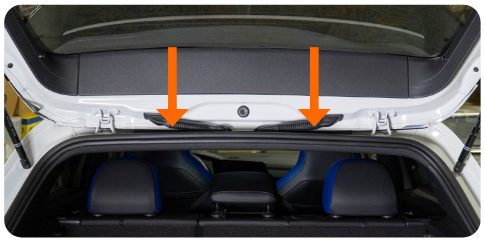 Two arrows pointing down at the headliner clip locations above the rear seats of a MK8 Golf
