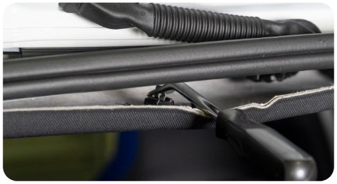 Trim pry tool inserted between the headliner and the body to release a clip