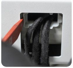 Wedge tool pressing the release tab on the hatch wiring loom grommet
