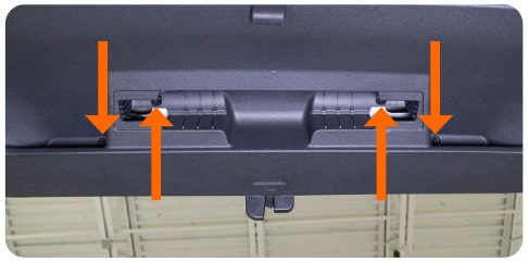 Four arrows pointing to the T25 screw locations on the hatch trim panel of a MK8 Golf