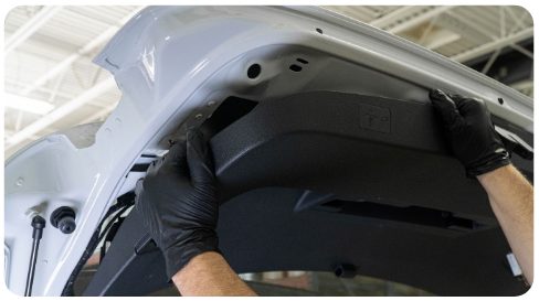 Hands pulling the hatch trim panel down and away from the hatch of a MK8 Golf